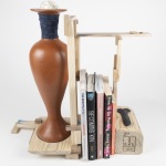 bookend to rupture, transform, repair, and care | 18.5in x 19in x 8in | reclaimed clay, reclaimed wood from shipping pallet, hand spun fiber reclaimed from discarded clothing, clay dug from the Niagara region, milkweed seed ball, milkweed tussock moth, beeswax, gold leaf, epoxy